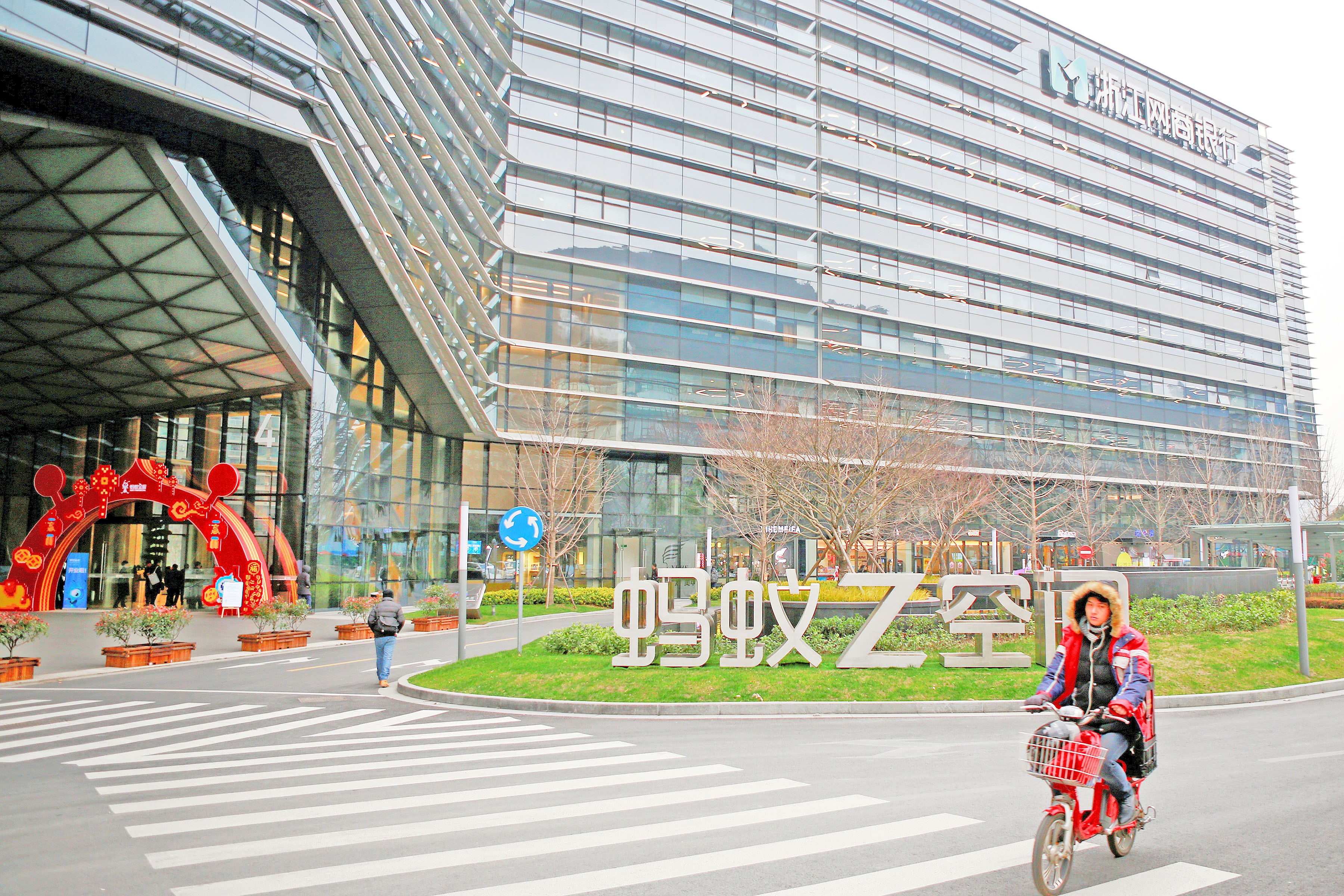 FILE PHOTO: Man cycles past MYbank logo in Hangzhou