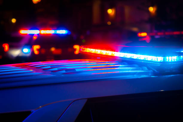 Red and blue police lights near a car crash in a city at night