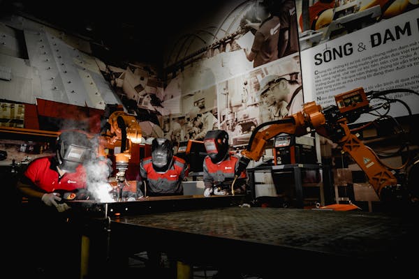 free-photo-of-men-in-protective-uniform-welding-with-robot-in-workshop